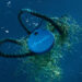Chipolo One: Ocean Edition floating in the water and tangled in nets