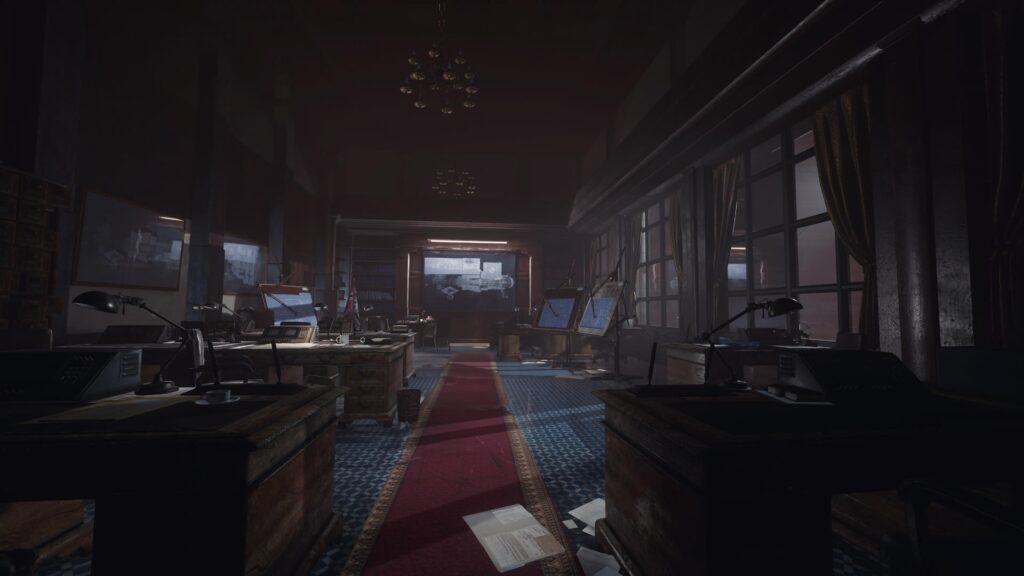 A dark room with many desks.