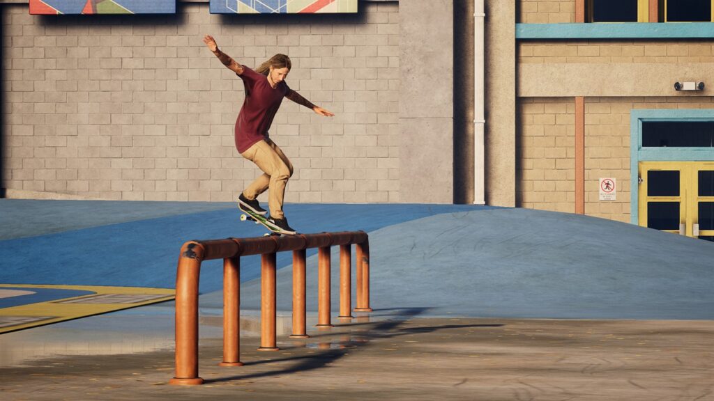 A skater grinding over an orangeskatebar. Their hands are balancing in the air