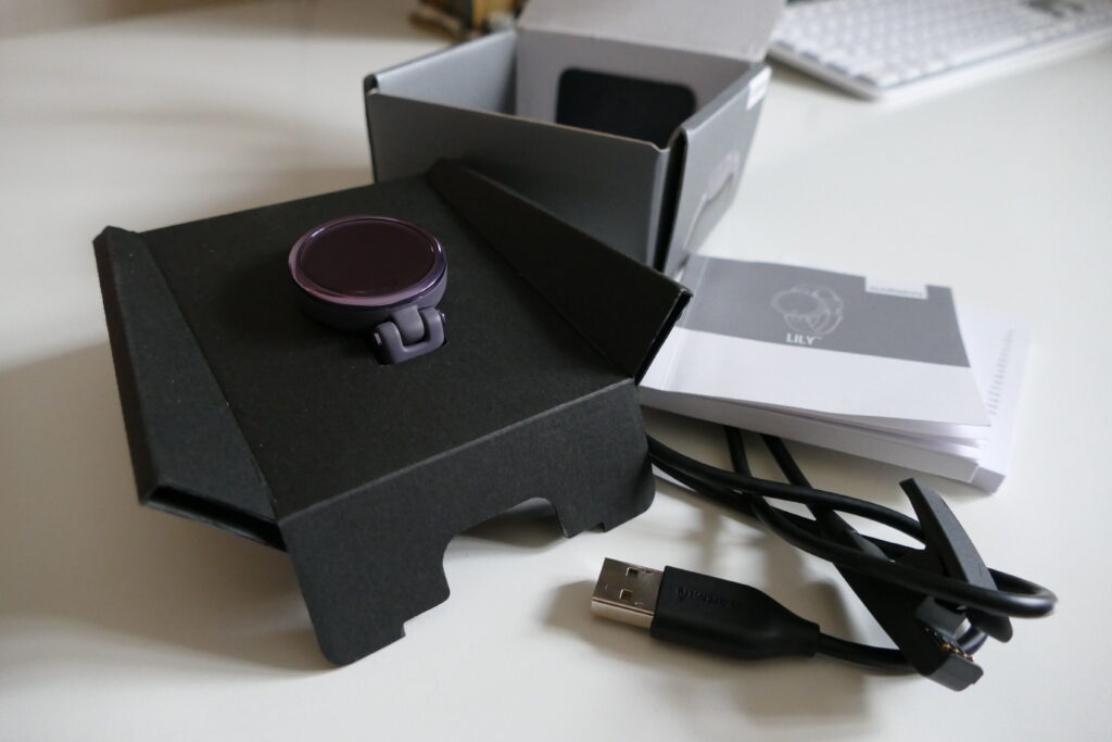Lily Garmin Sport watch, charging cable and instruction manual in front of box