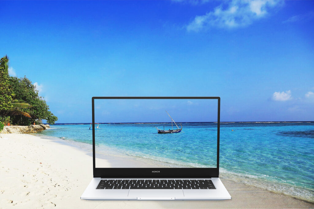 The computer showing a beachy scene with a beach in the background