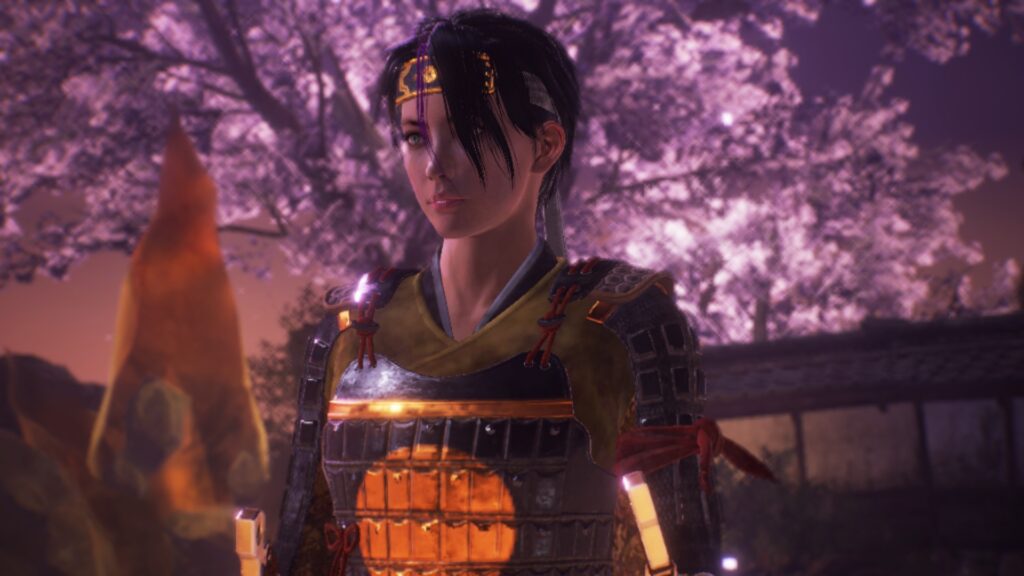 A female character wearing armour stands in the foreground, in the background there is a building and a cherry blossom tree