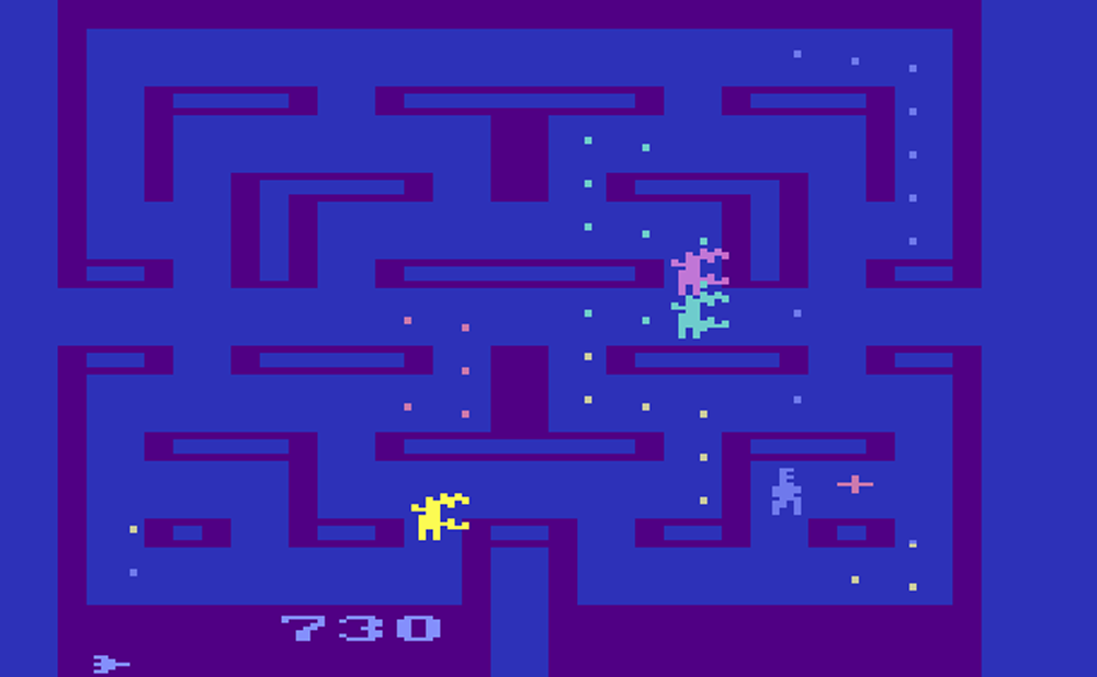 A 2D PAC-MAN style maze is shown, with the player sprite being chased by three other alien sprites.