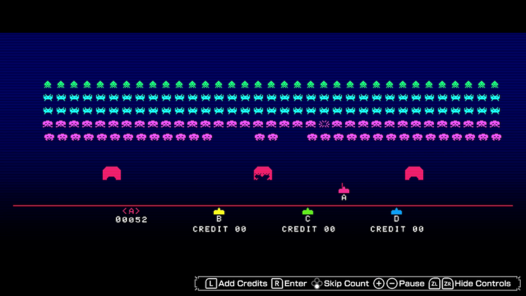 Invaders descend the screen on a blue background in widescreen, below are defences and a defender