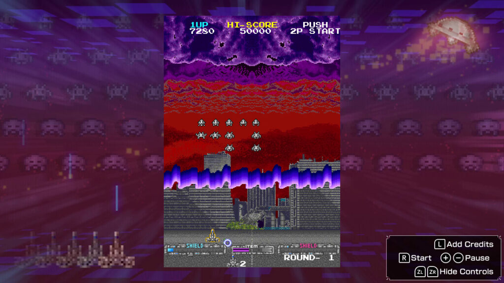 A purple sky which turns into red with skyscrapers in the background, invaders descend the screen in the middle with a defender at the bottom with a 'shield' bar