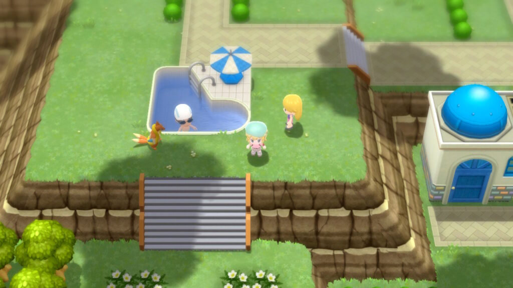 A trainer sits in a pool with its Buizel standing by.