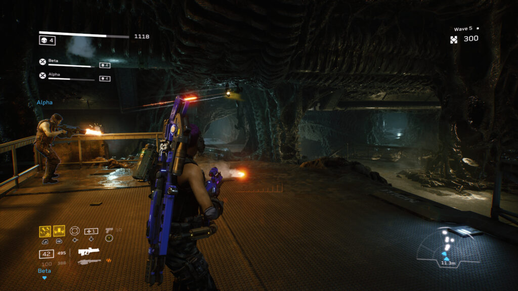 A Colonial Marin stands on a platform with an AI synthetic teammate to the left. Alien hive structure surrounds the characters.
