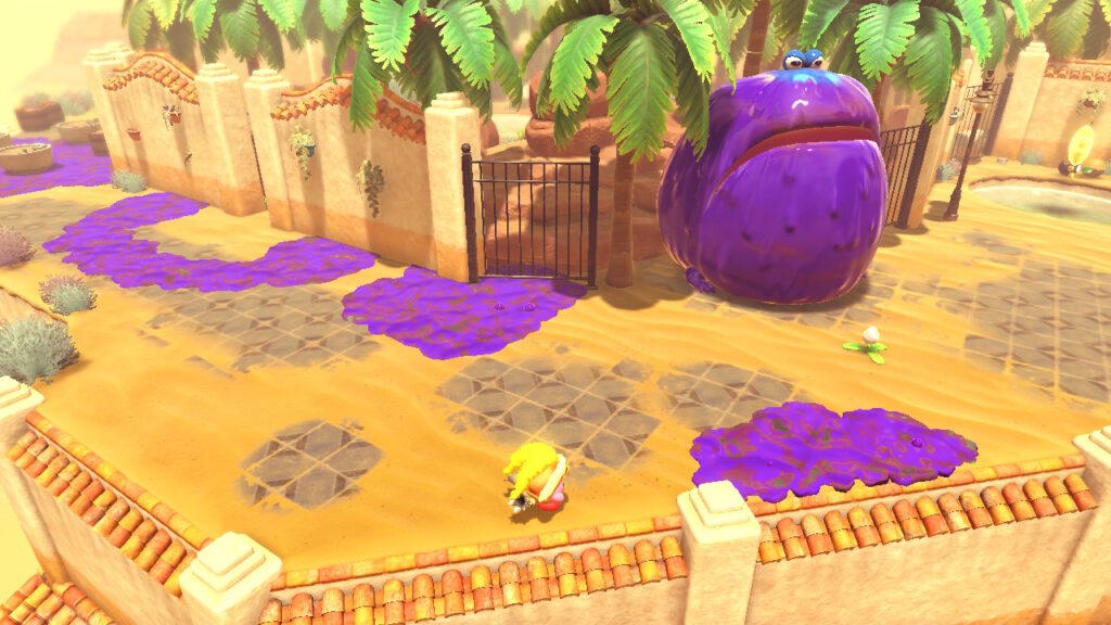 Kirby in an oasis level with a purple goo monster.