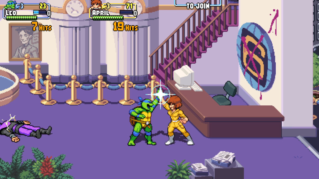 Leonardo and April high five while a member of the Foot Clan lies defeated on the floor partially off-screen