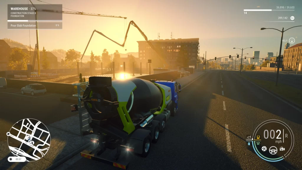 A concrete mixer drives along a road to a construction site at sunset