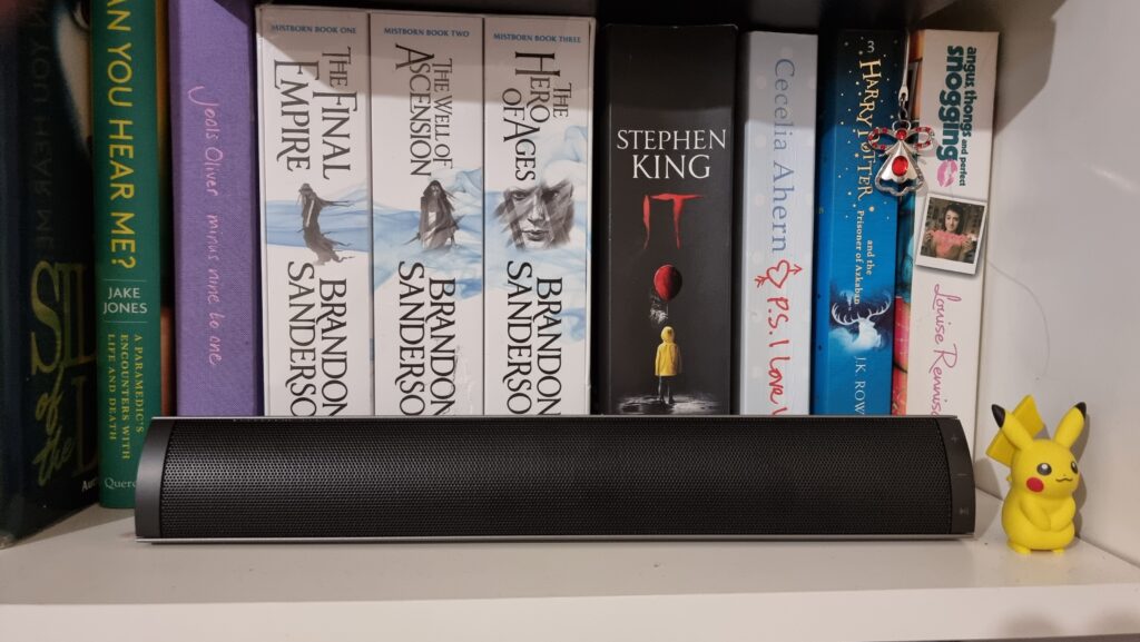 MF200 on a shelf with books behind it and a character beside it
