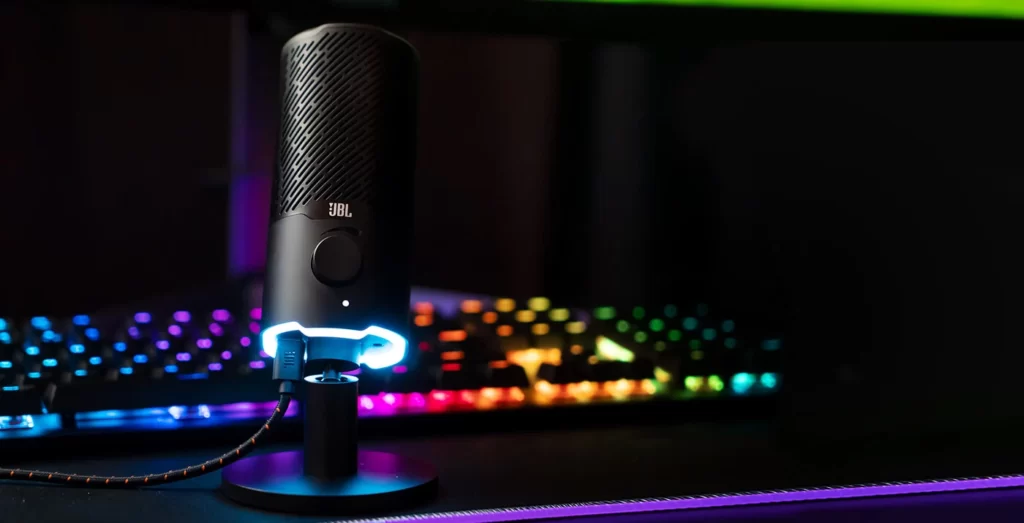 The JBL Quantum Stream sits in front of an RGB keyboard in the dark.