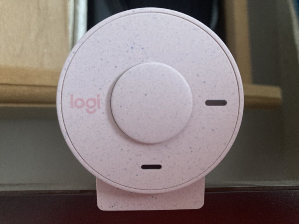 The Logitech Brio 300 seated on top of a monitor with the privacy shutter closed