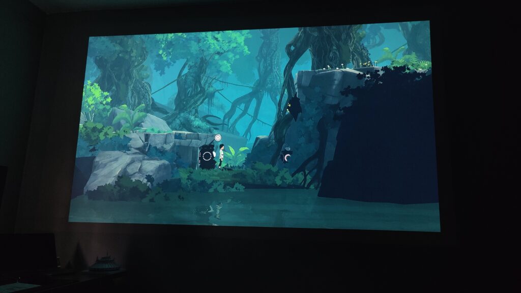 A green watercolor landscape from the game planet of Lana is projected on a wall
