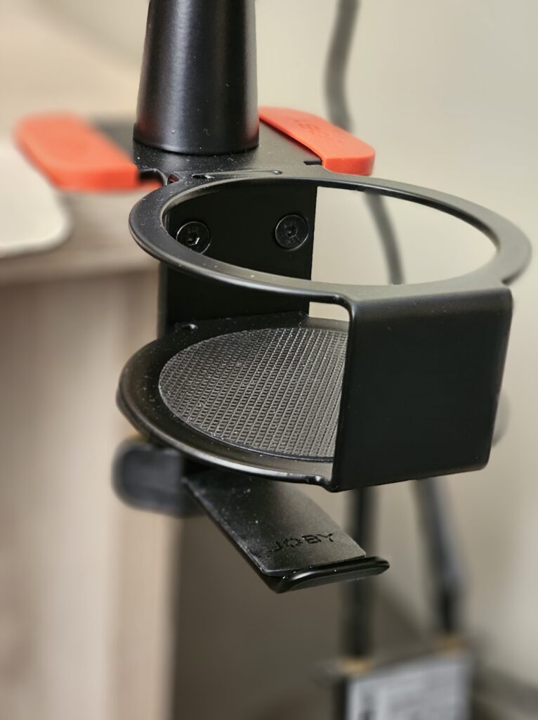 Close-up of the drinks holder and headphone hook on the JOBY Wavo Boom Arm displaying the rubberised base of the drinks holder and the hook being situated below it