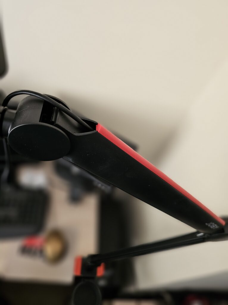 A picture showing the cable channel in the JOBY Wavo Boom Arm with a cable running down it and the red covers in place