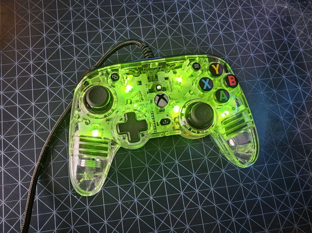 The Nacon Pro Compact Controller Colorlight lit up in green