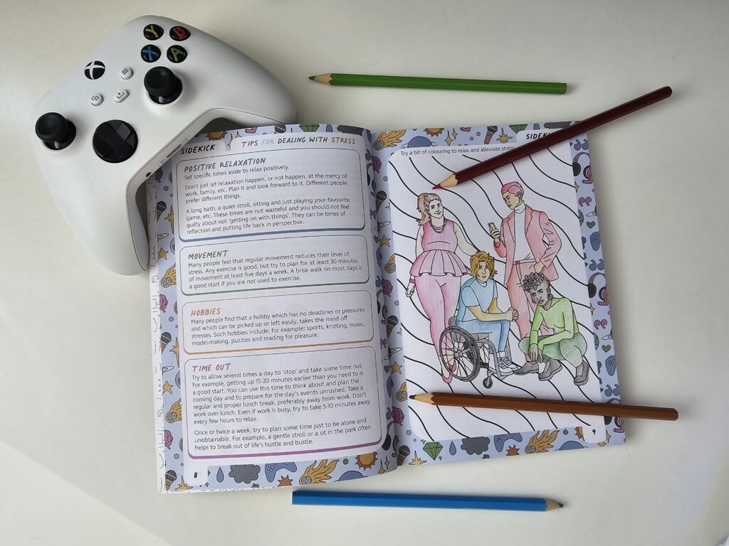The Sidekick journal open to a colouring page with pencils around it and an Xbox controller