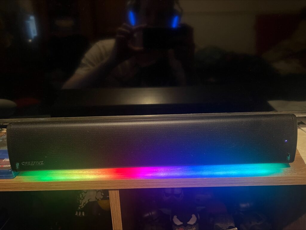 A photograph of the Sound Blaster GS3 sound bar in use by our reviewer. The RGB lights are turned on, and glowing in rainbow colours.