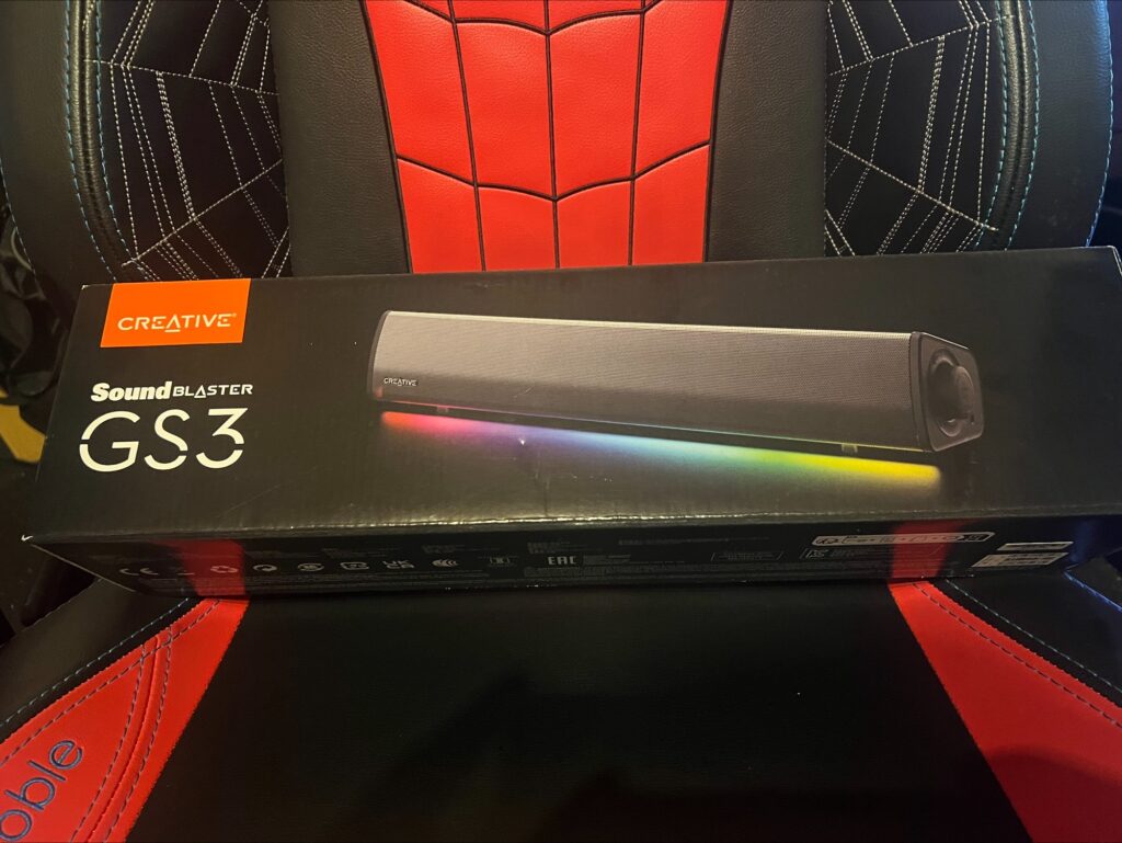 A photograph of the exterior of the box for the Creative Sound Blaster GS3 sound bar. The front shows the sound bar with its RGB lighting in use.