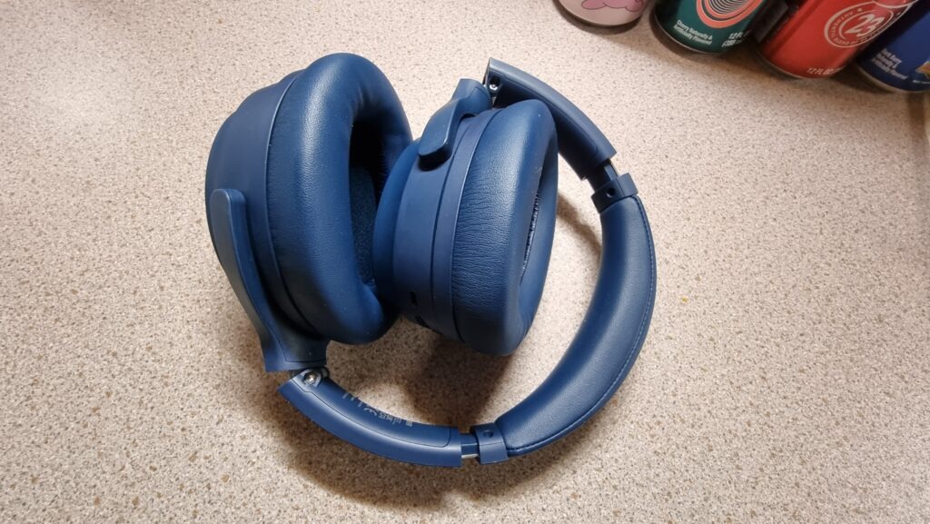 A close-up photograph of the Edifier WH700NB wireless headphones in navy blue with the ear cups folded down.