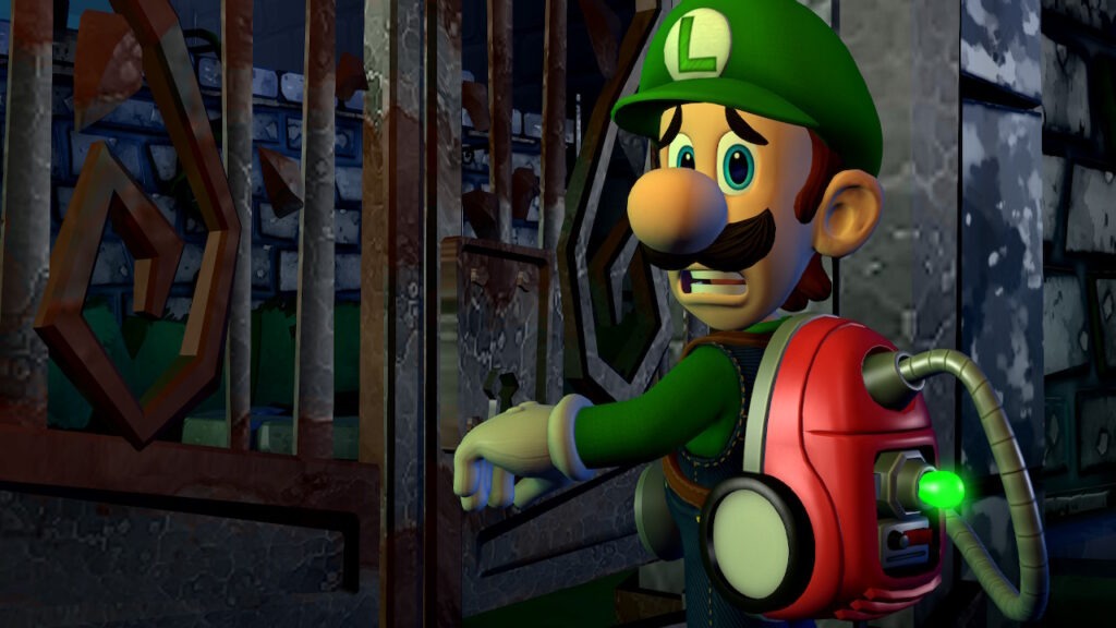 Luigi stands in front of a mansion gate. The gate looks to be old and rusty. A stone wall runs around the side of the property showing age and decay. Luigi's face shows that he is scared and cautious as he enters the gate.