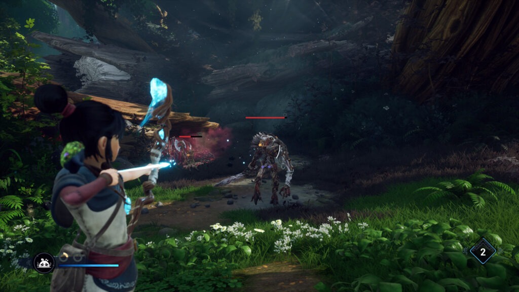Kena holds her magical staff now used as a bow and targets a wooden golem coming towards her. A large fallen tree looms in the background.