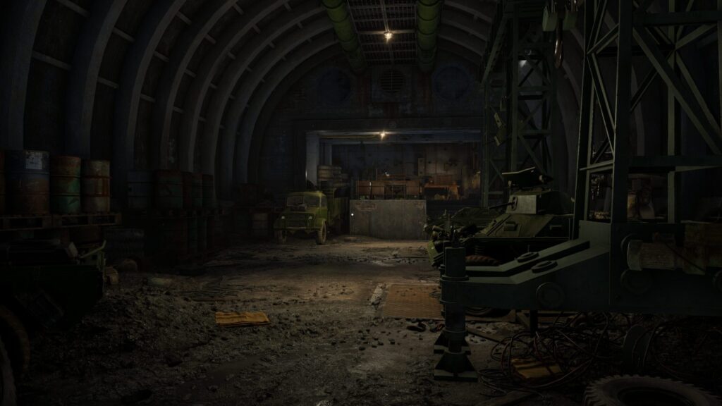 Interior of a bunker in Atomfall with assorted military vehicles inside