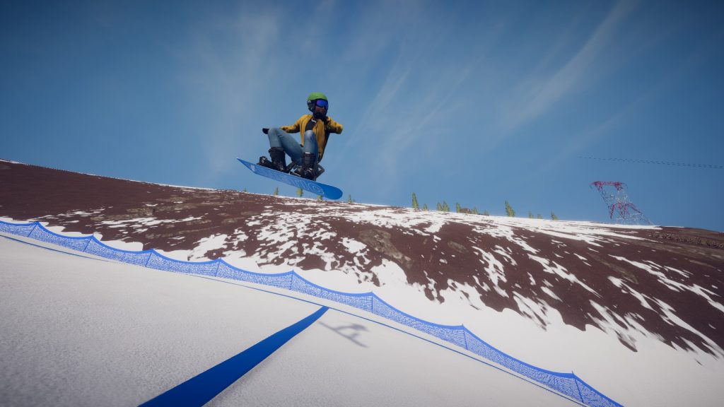 A snowboarder riding down a hill at a side angle.