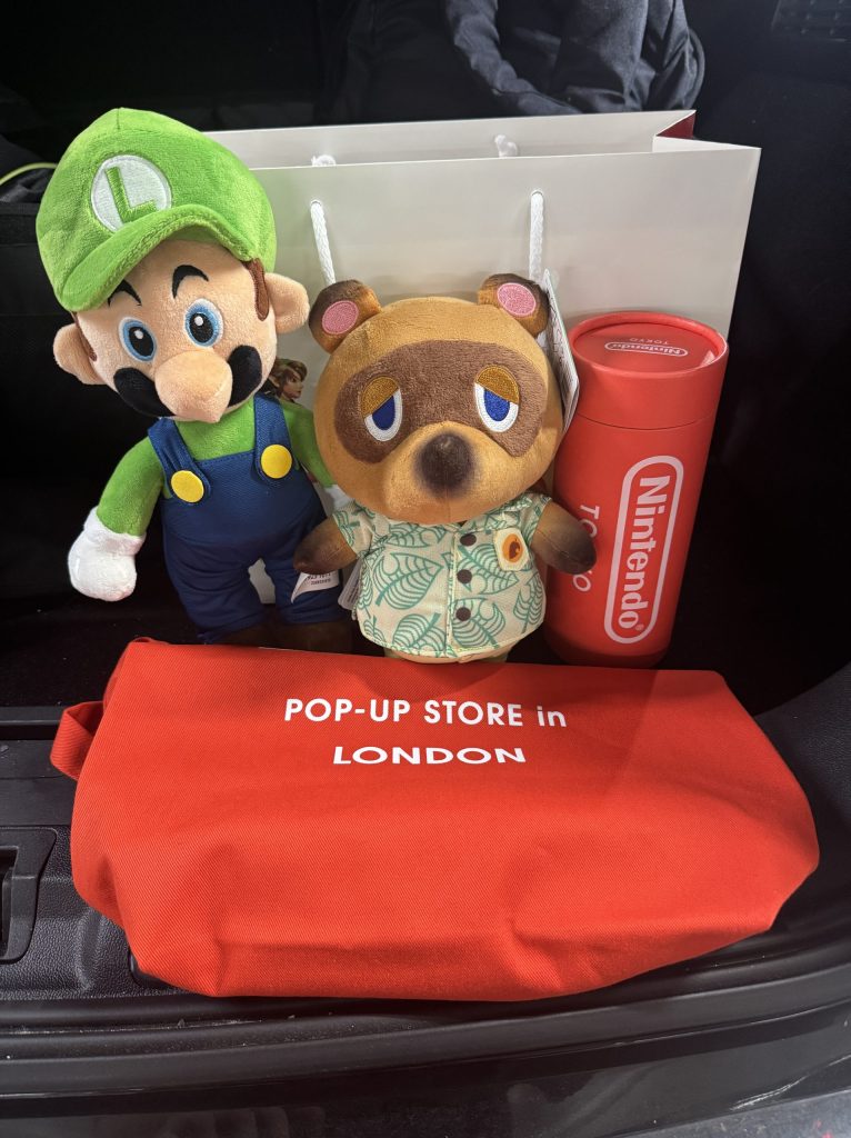 Luigi, Tom Nook plushies,  a Nintendo bag and T-shirt in a tube